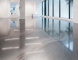 Luxurious metallic epoxy floor with flowing black and gold marble-like effects