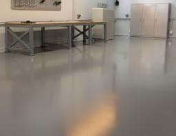 Clean uniform solid-colour blue plain epoxy floor in a Sydney workshop