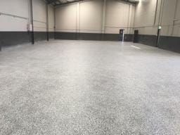 Warehouse floor finished with light epoxy flake flooring by DaniCrete